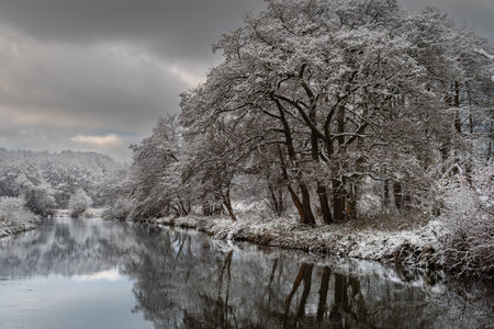 Winter landscape with river and trees covered with hoarfrost and snowの写真素材