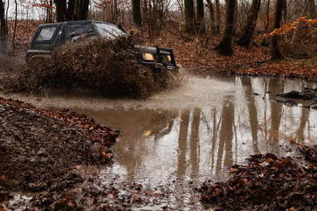 Off-road vehicle on a muddy road in the autumn forest