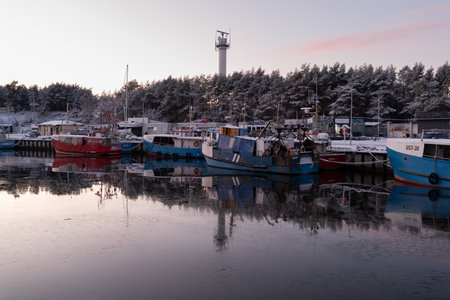 Fishing boats moored in a small harbor on a winter eveningの写真素材