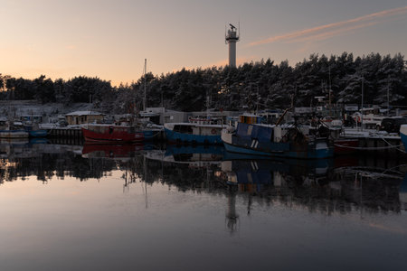 Fishing boats moored in a small harbor in the winter.の写真素材