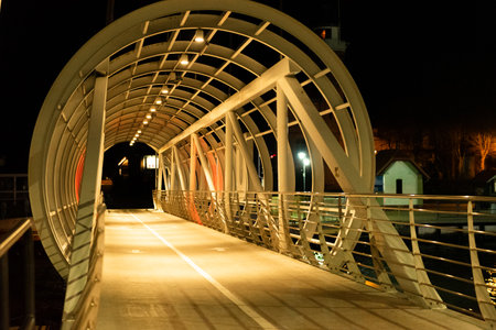 Pedestrian bridge over the river at night in the city. Ustka, Polandの写真素材