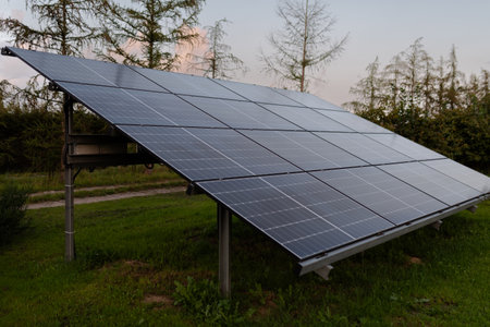 Solar panels on a green meadow in the evening. Alternative energy sourceの写真素材