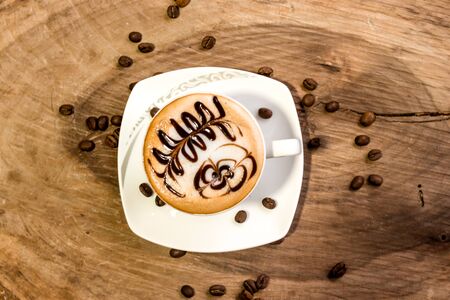 coffee cup latte art made with organic coffee, chocolate and coffee beans on background and on wooden backgroundの写真素材