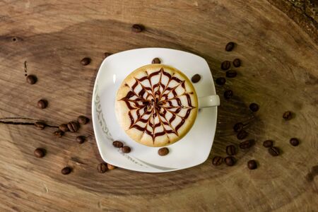 coffee cup latte art made with organic coffee, chocolate and coffee beans on background and on wooden backgroundの写真素材