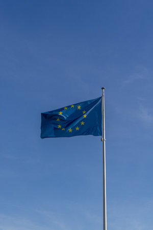 Waving European flag iin the background blue cloudless sky