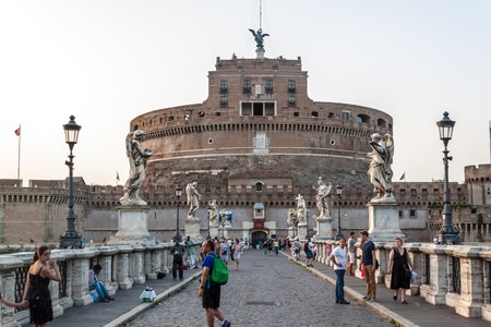 ROME - JUNE 24: Tourists cross St. Angel's bridge with its peddlers, in the background the Castle of St. Angel (Emperor Adrian's Mausoleum) on June 24, 2014 in Romeのeditorial素材