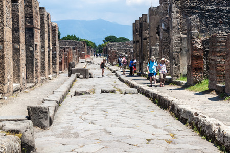 POMPEII, ITALY - JULY 27: Tourists visit antique ruins of town Pompeii, Italy on July 27, 2014. Pompeii was destroyed and buried with ash and pumice after Vesuvius eruption in 79 AD.のeditorial素材