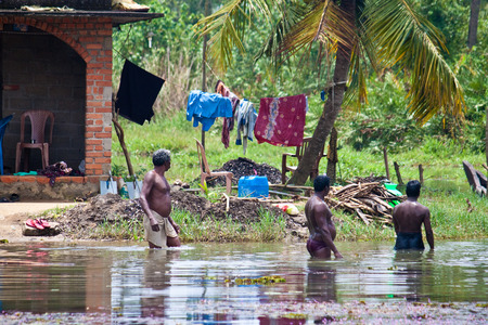 BACKWATERS, INDIA - AUGUST 24: Bathing men on August 24, 2011 in Backwaters, India. Backwaters are a network of interconnected canals, rivers and lakes.のeditorial素材