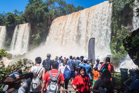 IGUAZU, ARGENTINA - FEB 6, 2015: Tourists admire Iguacu (Iguazu) falls on a border of Brazil and Argentinaのeditorial素材