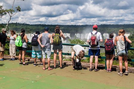IGUACU, BRAZIL - FEB 5, 2015: Tourists admire Iguacu (Iguazu) falls on a border of Brazil and Argentinaのeditorial素材
