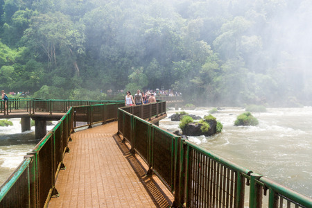 IGUACU, BRAZIL - FEB 5, 2015: Tourists admire Iguacu (Iguazu) falls on a border of Brazil and Argentinaのeditorial素材