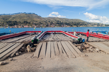 TIQUINA STRAIT, BOLIVIA - MAY 11, 2015: Rafts are prepared for transport of vehicles across the Tiquina strait at Titicaca lake, Boliviaのeditorial素材