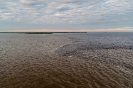 The Meeting of Waters (Encontro das Aguas) is the confluence between the Rio Negro river, with dark...