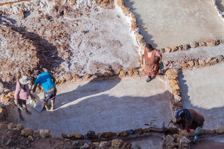 SALINAS, PERU - MAY 21, 2015: Workers at salt extraction pans (Salinas) in Sacred Valley of Incas, Peruのeditorial素材
