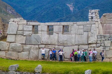 MACHU PICCHU, PERU - MAY 18, 2015: Tourists in front of Tmple of the Three Windows at Machu Picchu ruins, Peru.のeditorial素材