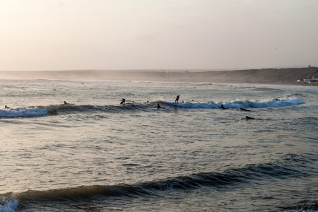HUANCHACO, PERU - JUNE 6, 2015: People surf in waves of an ocean in Huanchaco, Peru.のeditorial素材