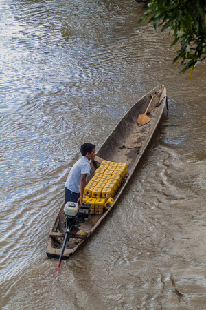 NAPO, PERU - JULY 15, 2015: Villager transports beer cans in a canoe on a river Napo, Peruのeditorial素材