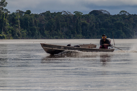 NUEVO ROCAFUERTE, ECUADOR - JULY 9, 2015: Villager on a dugout canoe called Peke Peke on a river Napo, Ecuadorのeditorial素材