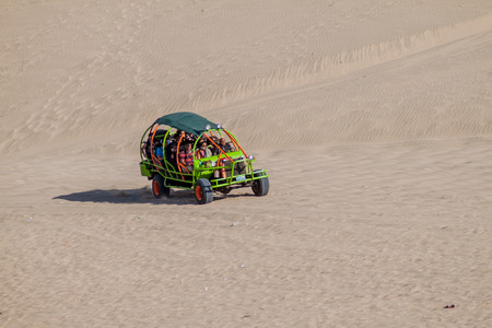 HUACACHINA, PERU - JUNE 1, 2015: Tourists on sand dune buggy trip to the dunes in Huacachina desert, Peruのeditorial素材