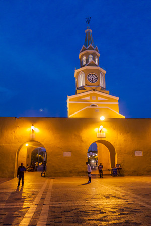 CARTAGENA DE INDIAS, COLOMBIA - AUG 27, 2015: People walk at the Plaza de los Coches in Cartagena during evening. Clock tower in the background.の写真素材