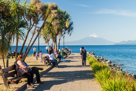 PUERTO VARAS, CHILE - MAR 23: People on a coast of Llanquihue lake in Puerto Varas town. Osorno volcano in the background, Chileのeditorial素材