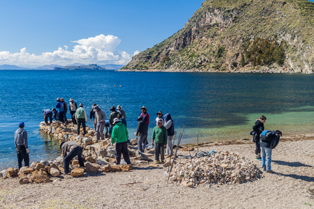 ISLA DEL SOL, BOLIVIA - MAY 12, 2015: Locals build a  stone pier in Challa village on Isla del Sol (Island of the Sun) in Titicaca lake, Boliviaのeditorial素材