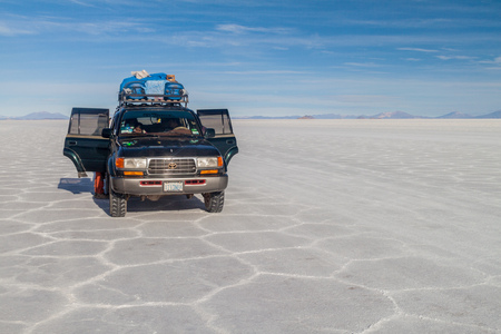 SALAR DE UYUNI, BOLIVIA - APRIL 17, 2015: 4WD with tourists at Salar de Uyuni salt flat, Boliviaのeditorial素材