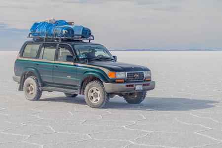SALAR DE UYUNI, BOLIVIA - APRIL 17, 2015: 4WD with tourists at Salar de Uyuni salt flat, Boliviaのeditorial素材