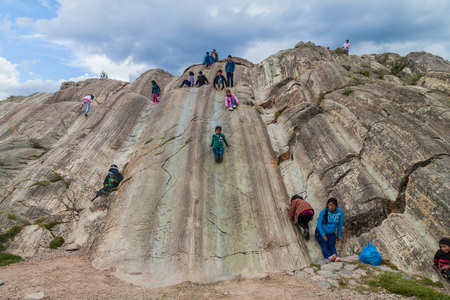 SACSAYWAMAN, PERU - MAY 24, 2015: People with children on natural slides at Inca's ruins of Sacsaywaman near Cuzco, Peru.のeditorial素材