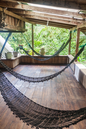MINDO, ECUADOR - JUNE 27, 2015: Hammocks in La Casa de Cecilia hostel in Mindo village.の写真素材