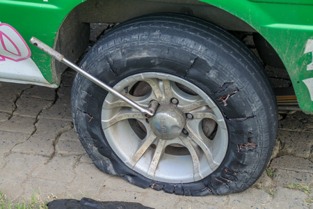NIEUW NICKERIE, SURINAME - AUGUST 9, 2015: Flat tire of a van on a surinamese coastal roadのeditorial素材