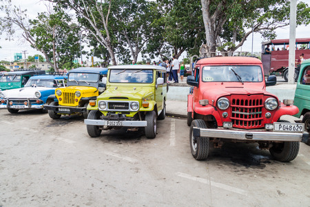 HOLGUIN,  CUBA - JAN 28, 2016: Old cars serving as shared taxis wait at the transport terminal in...