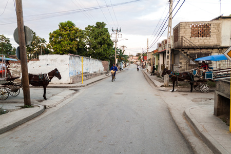 LAS TUNAS, CUBA - JAN 27, 2016: Two horse carriags cross a street in Las Tunas.のeditorial素材
