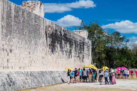 CHICHEN ITZA, MEXICO - FEB 26, 2016: Crowds of tourists visit The great ball game court at the archeological site Chichen Itza.のeditorial素材