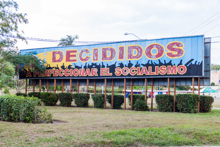 LAS TUNAS, CUBA - JAN 27, 2016: Propaganda billboard at Plaza de la Revolucion (Square of the Revolution) in Las Tunas. It says: Decided to prefect the socialism.のeditorial素材