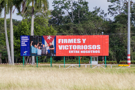 HOLGUIN, CUBA - JAN 28, 2016: Propaganda billboard at Plaza de la Revolucion (Square of the Revolution) in Holguin. It says: Firm and victorious among us.のeditorial素材