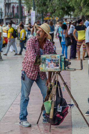HAVANA, CUBA - FEB 20, 2016: Street photographer using a vintage camera in Parque Central, the center of Havana.のeditorial素材