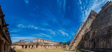 UXMAL, MEXICO - FEB 28, 2016: Tourists between the Nun's Quadrangle (Cuadrangulo de las Monjas) building complex and the Pyramid of the Magician (Piramide del adivino) at the ruins of the ancient Mayan city Uxmal, Mexicoのeditorial素材