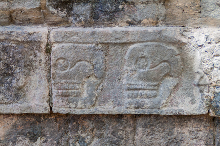 Carved skulls at the Platform of Sculls at the archeological site Chichen Itza, Mexicoの写真素材