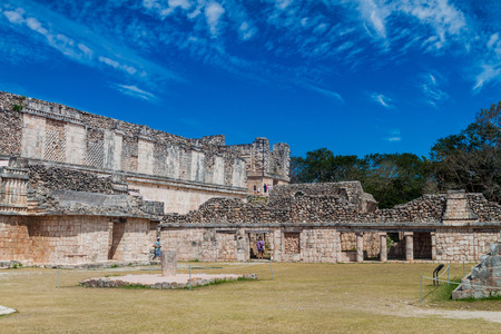 UXMAL, MEXICO - FEB 28, 2016: Tourists between the Nun's Quadrangle (Cuadrangulo de las Monjas) building complex and the Pyramid of the Magician (Piramide del adivino) at the ruins of the ancient Mayan city Uxmal, Mexicoのeditorial素材