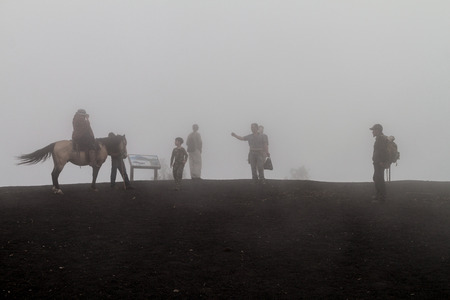 PACAYA, GUATEMALA - MAR 28, 2016: Tourists visiting the Pacaya volcano in the mist, Guatemalaのeditorial素材
