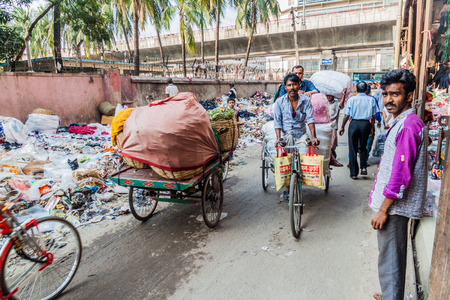 DHAKA, BANGLADESH - NOVEMBER 21, 2016: Piles of garbage and rickshaws at Siddique Bazar street in central Dhaka, Bangladeshのeditorial素材