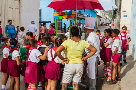 TRINIDAD, CUBA - FEB 8, 2016: Group of Young Pioneer girls and boys at a street food stall in Trinidad, Cuba.のeditorial素材