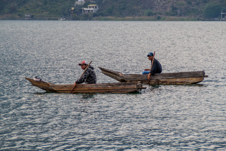 SANTIAGO ATITLAN, GUATEMALA - MARCH 23, 2016: Fishermen on traditional wooden boats on Atitlan lake near Santiago Atitlan village.のeditorial素材