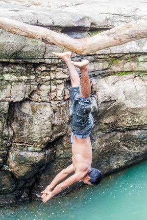 GUALACA, PANAMA - MAY 23, 2016: Local male jumps in a water in Los Cangilones de Gualaca - mini canyon in Panamaのeditorial素材