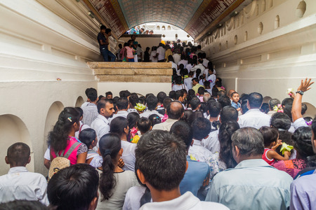 KANDY, SRI LANKA - JULY 19, 2016: White clothed Buddhist devotees wait in a queue at the entrance to the Temple of the Sacred Tooth Relic during Poya (Full Moon) holiday.のeditorial素材
