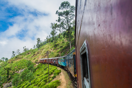 IDALGASHINNA, SRI LANKA - JULY 16, 2016: Local train rides near Idalgashinna village. Locals hang out of doors.のeditorial素材