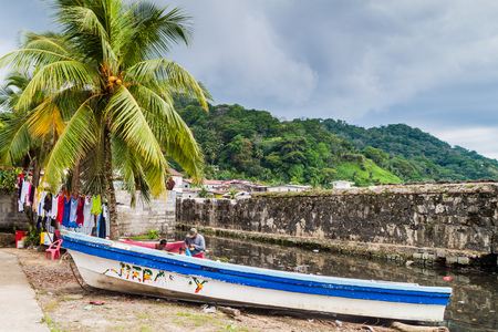 PORTOBELO, PANAMA  - MAY 28, 2016: Drying laundry and a fishing boat in Portobelo village, Panamaのeditorial素材