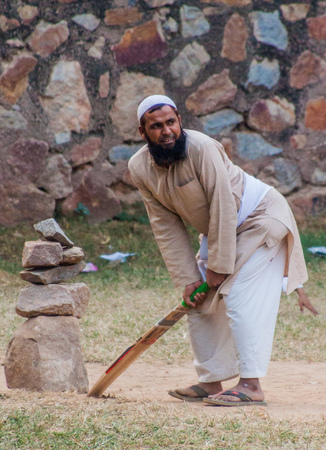 DELHI, INDIA - OCTOBER 23, 2016:  Muslim man plays cricket near Jamali Kamali Mosque in Delhi, Indiaのeditorial素材