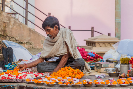 VARANASI, INDIA - OCTOBER 25, 2016: Street vendor of religious offerings in Varanasi, India.のeditorial素材